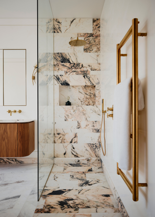 A marble shower surround from the ceiling edge which covers the floor