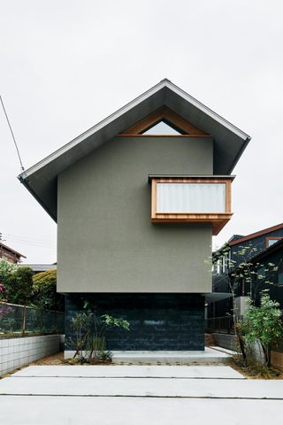 exterior of japanese house with asymmetrical windows and pitched roof