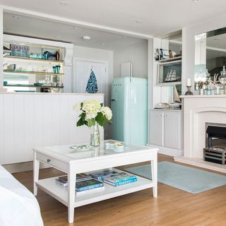 white themed kitchen with wooden flooring and cupboard