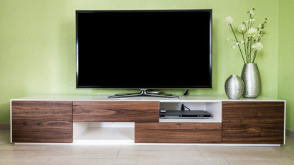 The best 43-inch TVs: Image depicts 43-inch TV on stand against green wall