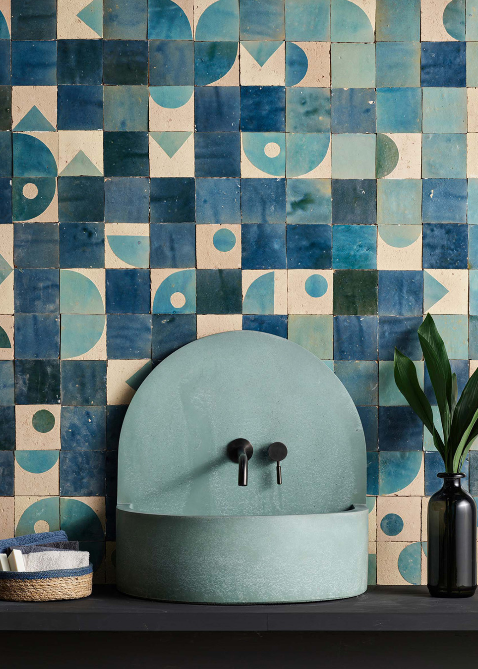 blue zellige tiles behind a light blue sink with some patterned tiles included in the splashback too