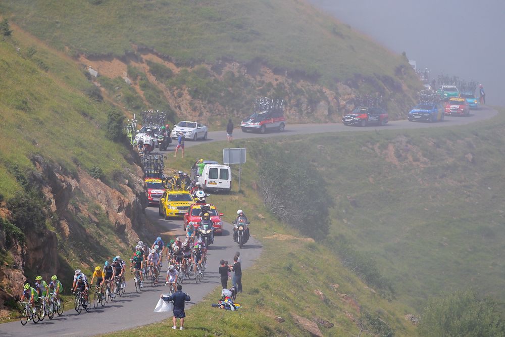 The peloton climbs out of the fog on the Port de Bales during stage 17 of the 2012 Tour de France from Bagneres-de-Luchon to Peyragudes.