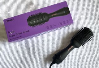 Contributor image showing the Amika 2.0 Blow Dryer Brush next to its box