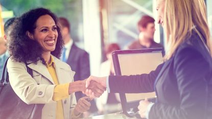 Customer shaking hands with bank teller at bank counter