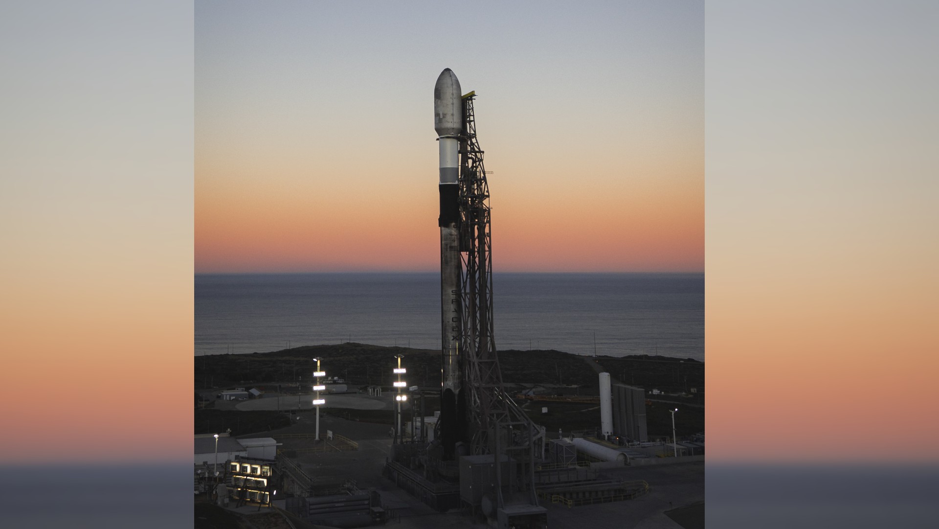 A SpaceX Falcon 9 rocket ready to launch by the sea.
