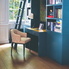 A desk built into a blue-painted home library