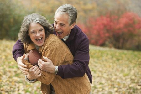 Happy older couple playing football
