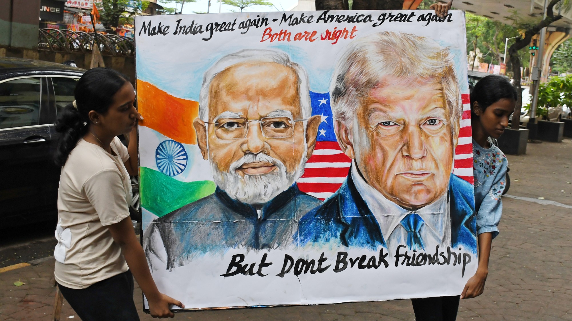Students from Gurukul School of Art carry a poster of Narendra Modi and Donald Trump outside their school
