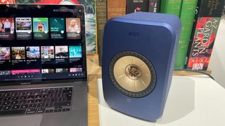 KEF LSX II speakers in blue finish placed on desk next to MacBook laptop