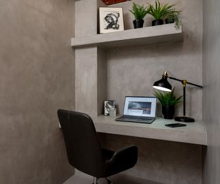 office space with the walls, floor and desk area covered with microcement