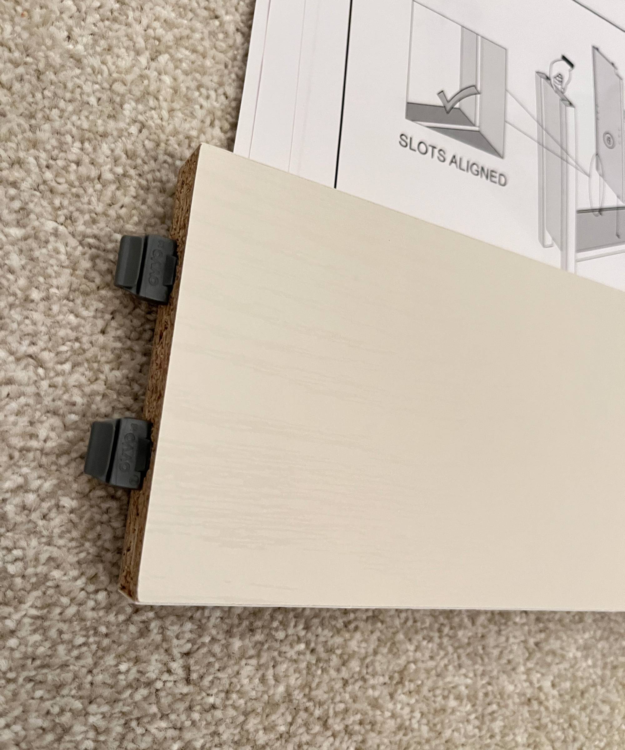 piece of furniture with dark grey plastic fixings at one end