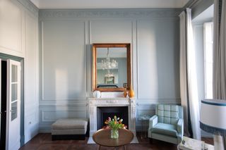 The Santa Maria Novella Master Room at The Place Firenze offers an en suit living area with a turquoise armchair and fresh flowers displayed