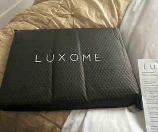 Luxome Luxury Sheet Set on top of a gold-toned comforter.