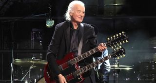 Led Zeppelin icon Jimmy Page plays his cherry red double-neck Gibson EDS-1275 at The Rock And Rock Hall Of Fame ceremony honouring Link Wray. He wears all black.