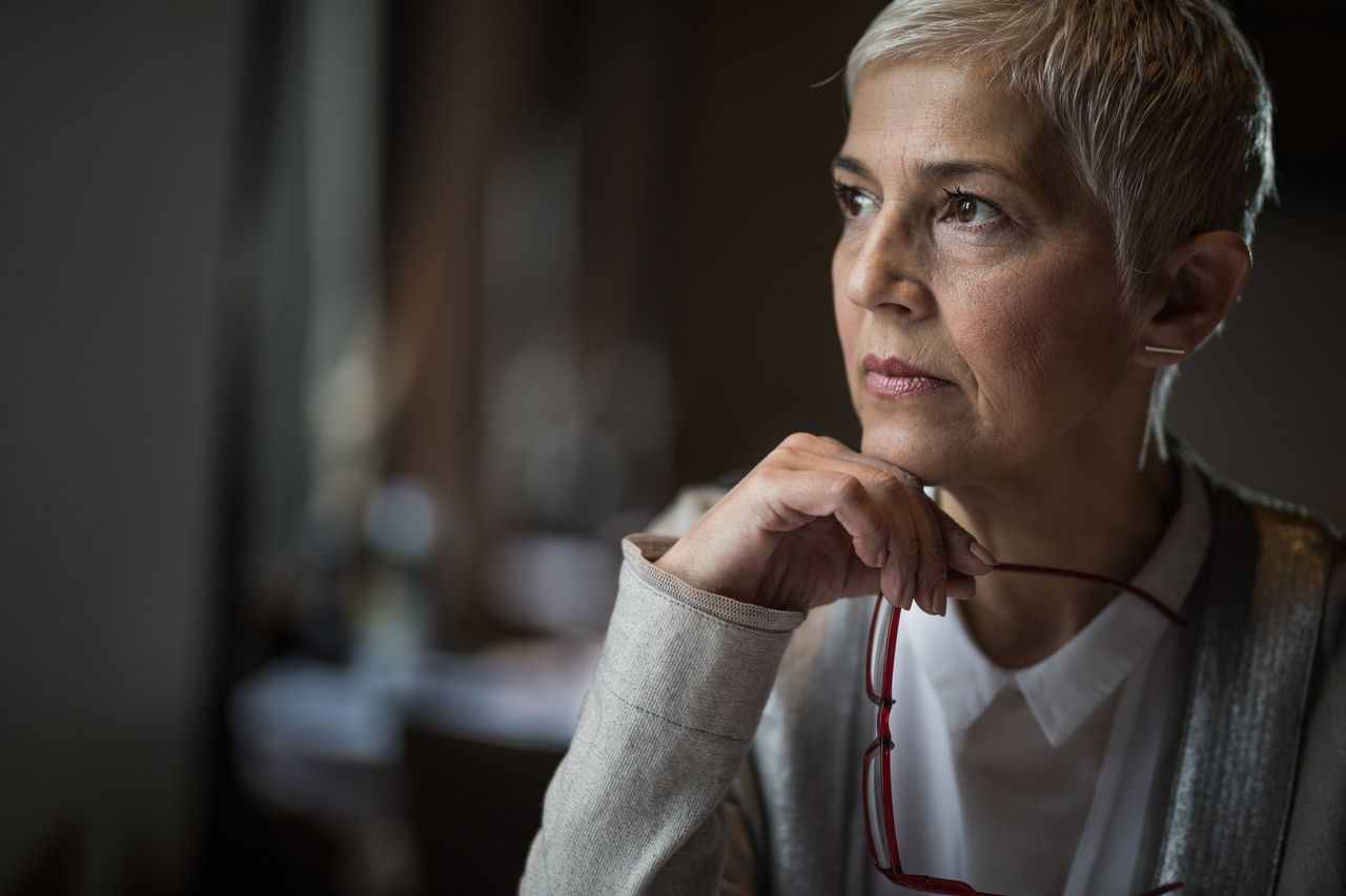 Middle age woman looking out of her window