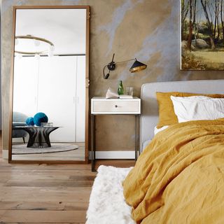 room with wooden flooring and big mirror