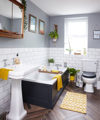 Grey bathroom with pops of yellow and white metro tiles on wall