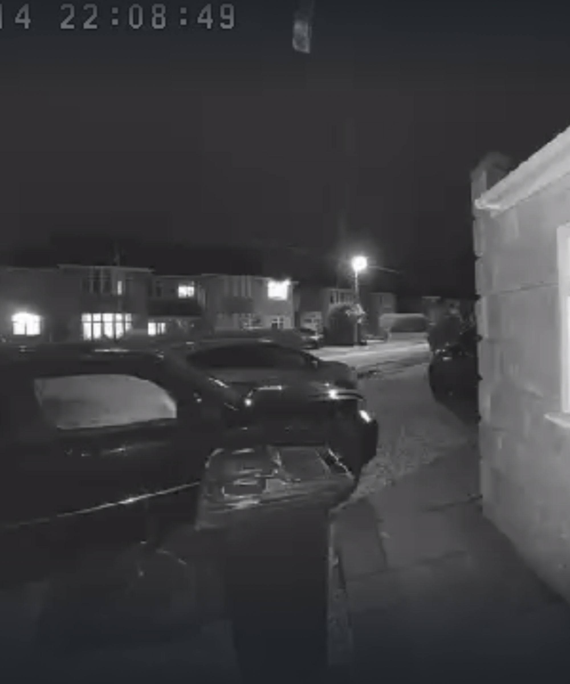 Screenshot of the Tapo D210 Video Doorbell in infrared mode, showing cars, lights, and houses.