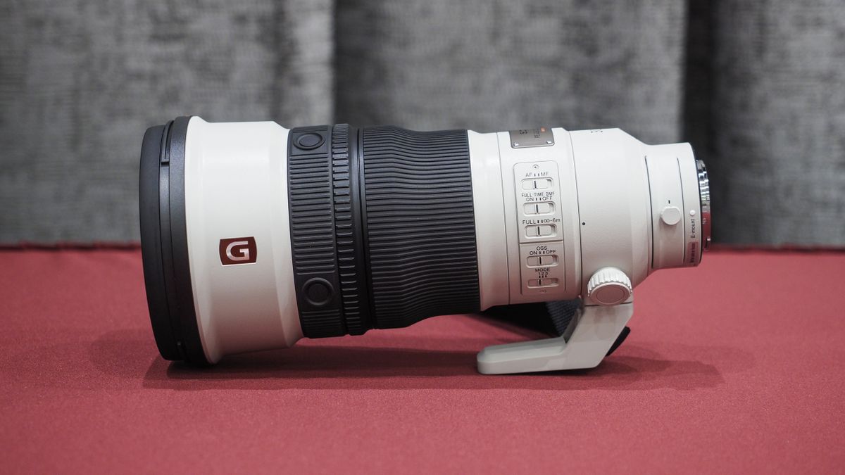 Sony FE 300mm f/2.8 GM OSS lens on a red table with grey curtains