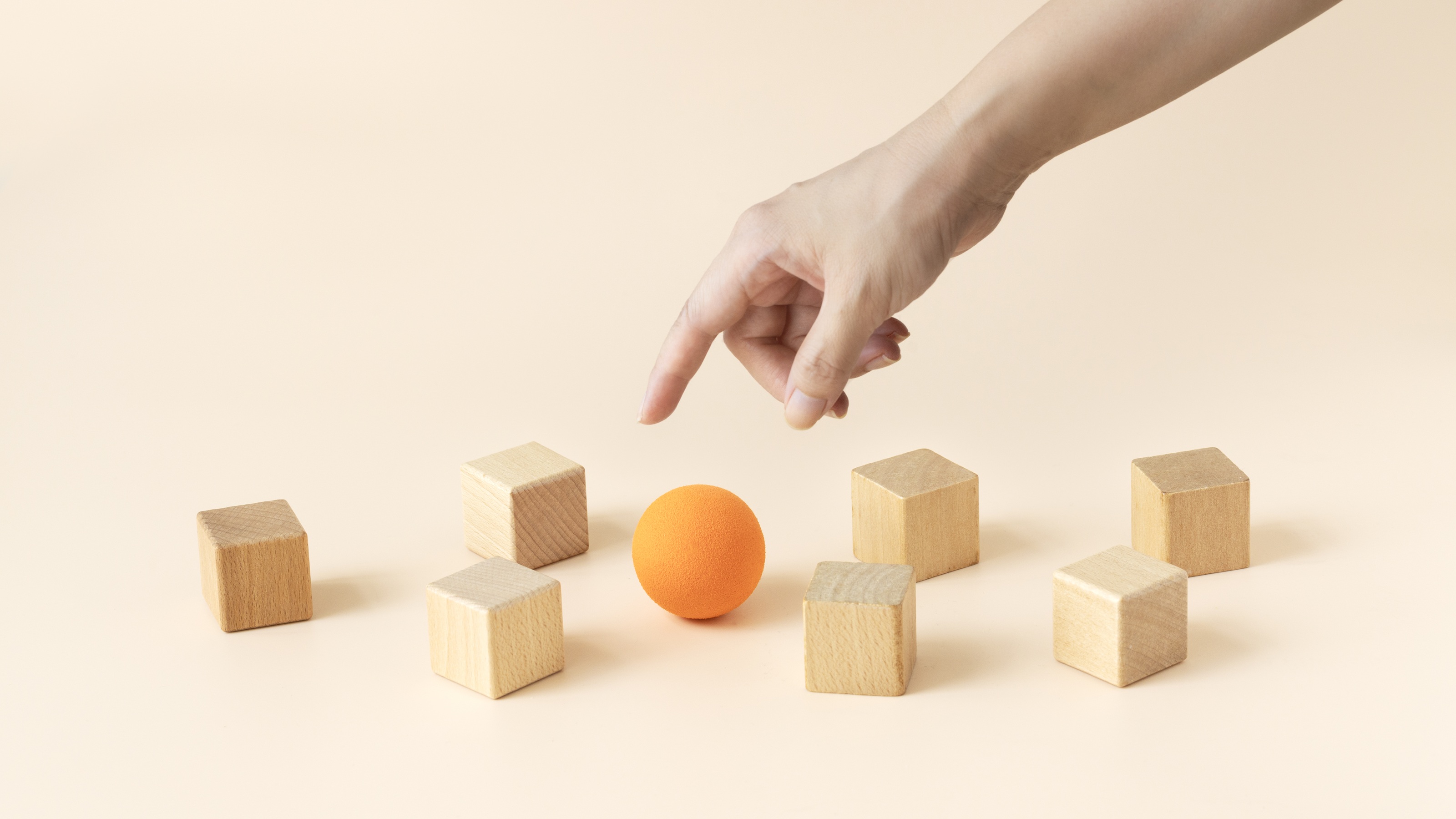 A large orange sphere surrounded by smaller wooden blocks.