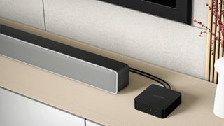 Press image of WiiM Pro with soundbar speaker on a sideboard