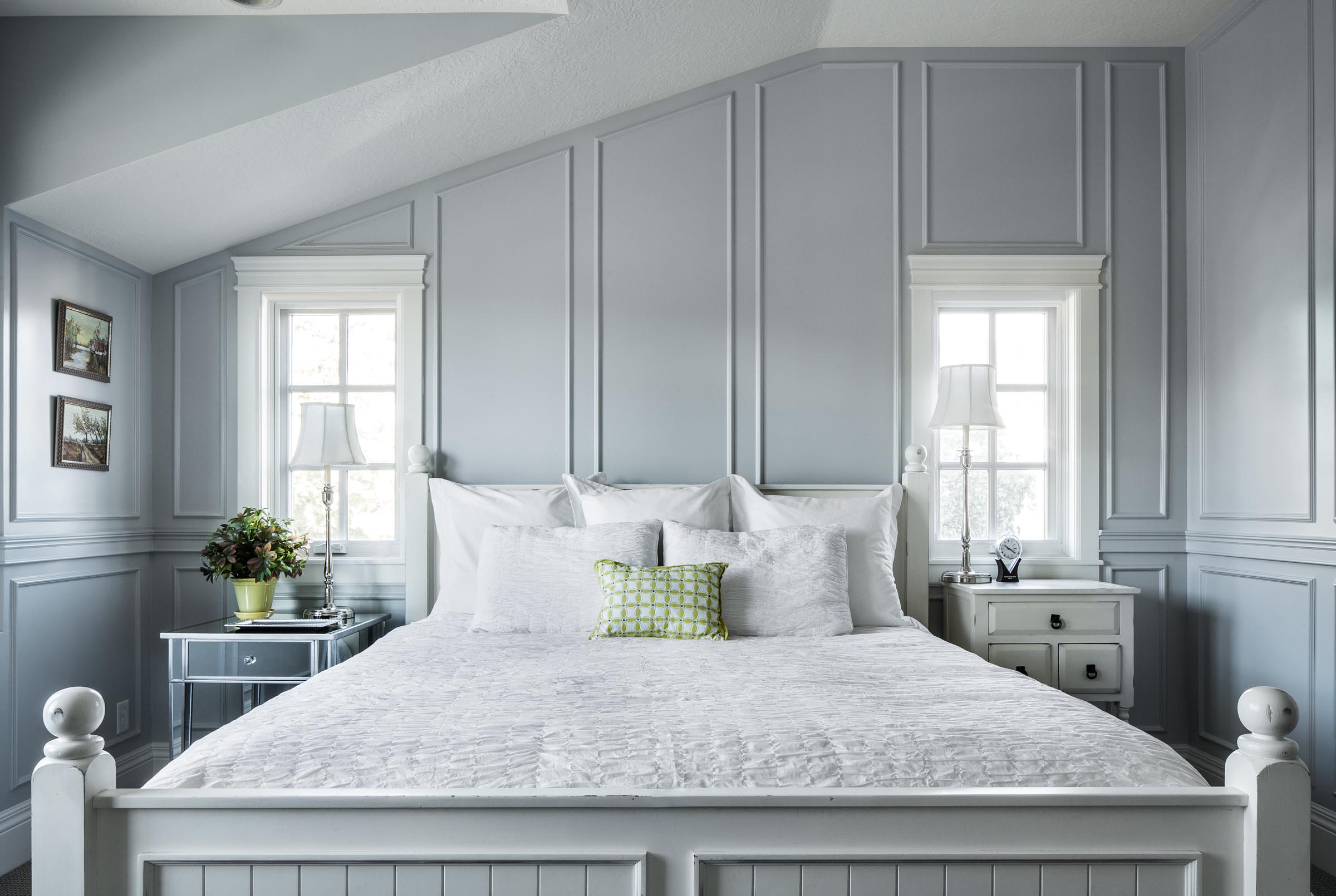 Grey wainscoting frames bed with white linen