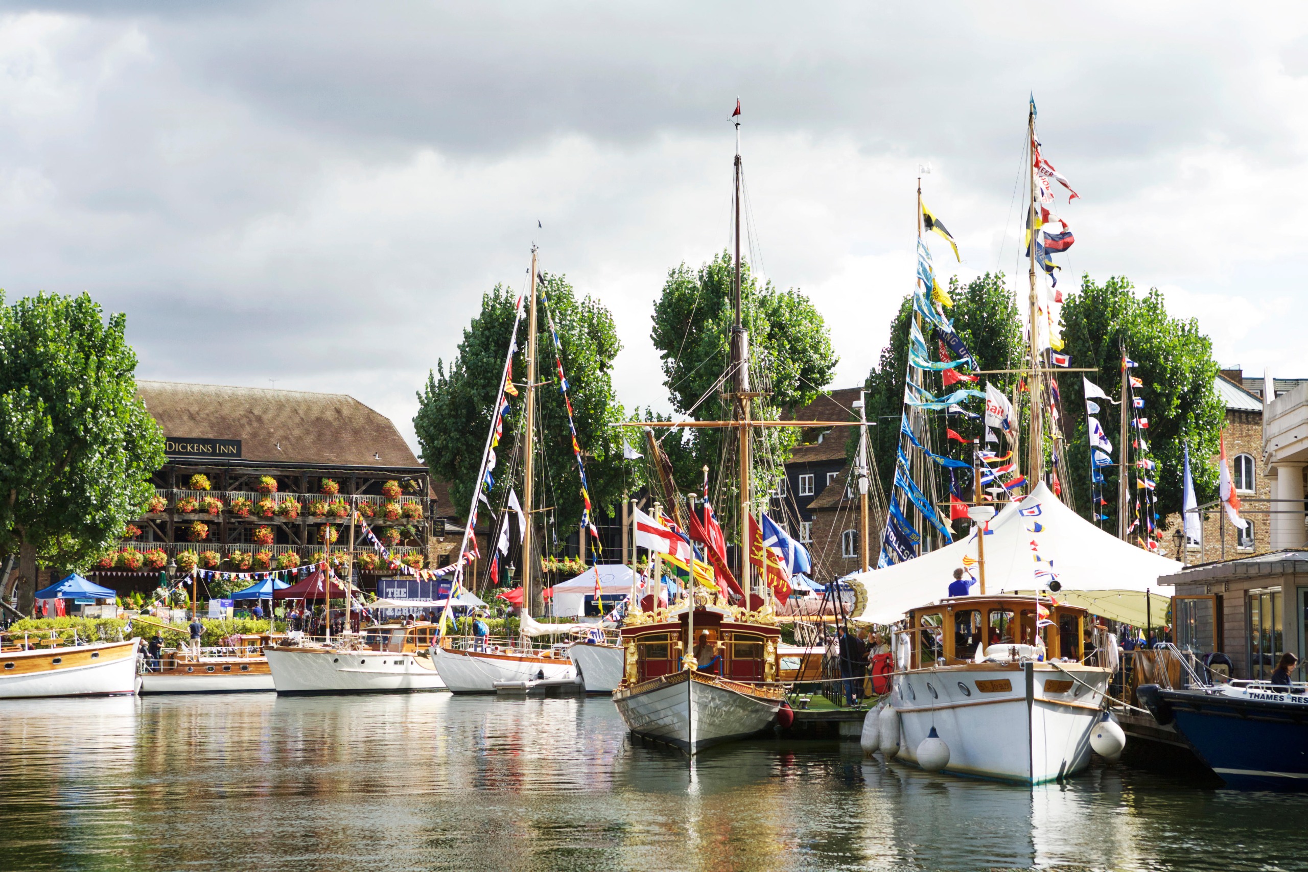 Elegant yachts occupy St Katharine Docks, flying pretty flags from their masts