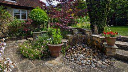 garden decor with stones: stone water feature in english garden