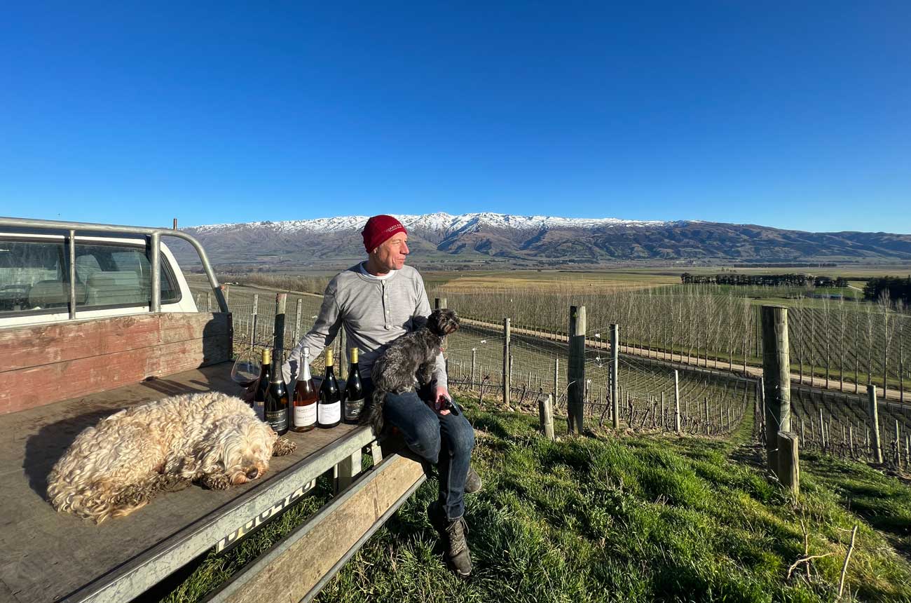 Rudi Bauer of Quartz Reef with dogs and wine in the vineyard