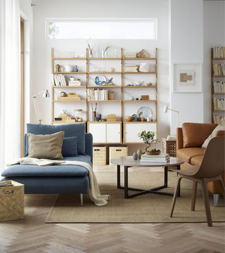 A contemporary living room with modular shelving unit, Herringbone style flooring decor and round coffee table