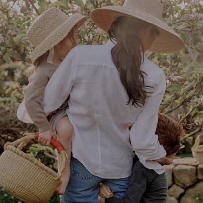 Meghan Markle wears a gold strapless gown and stands and a podium, and Meghan stands in the garden with her children, both of whom had red hair, Princess Lilibet and Prince Archie