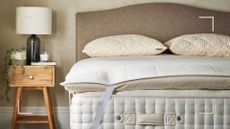 neutral bedroom with a mattress with a mattress topper and pillows without covers to show why wool bedding keeps you cool