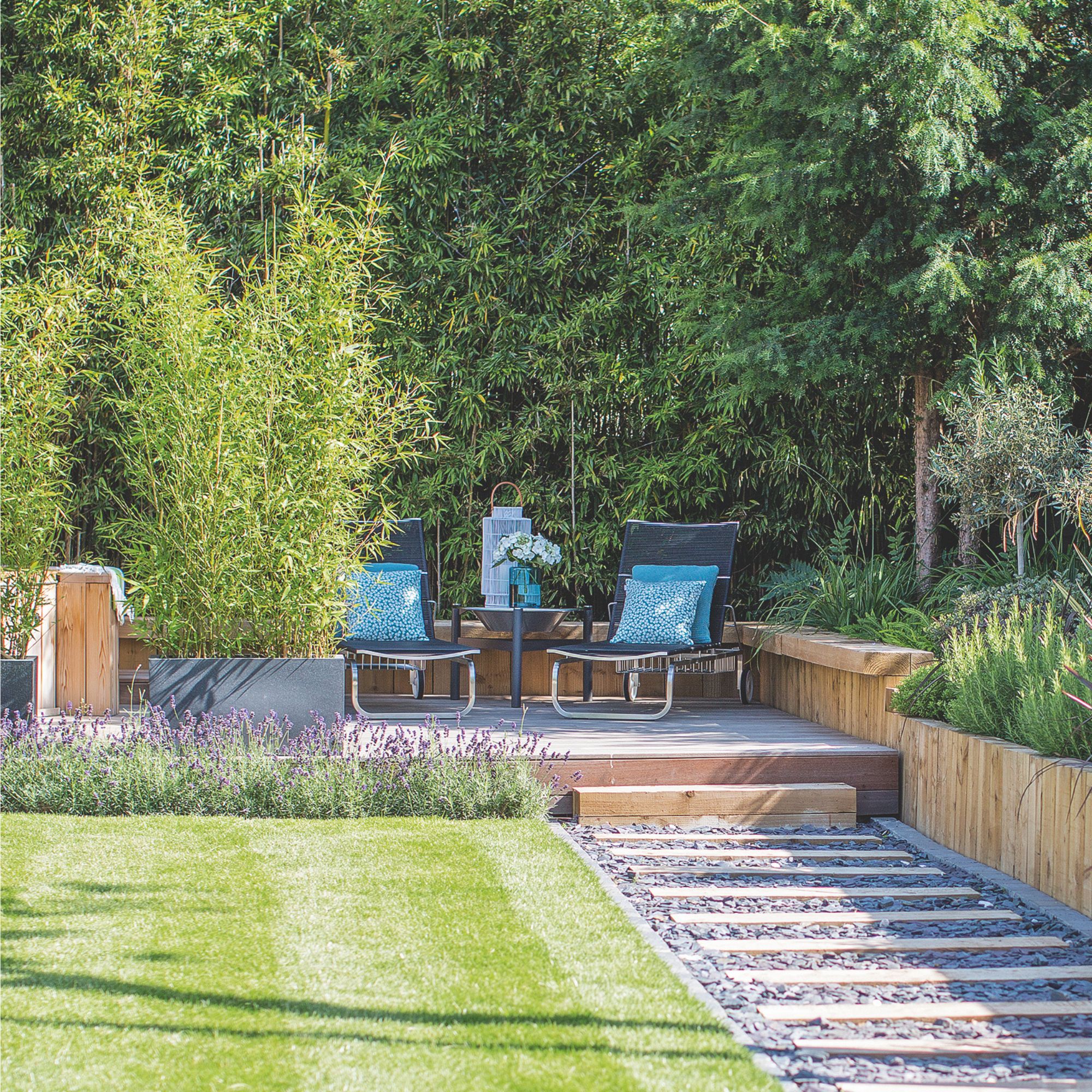 Decked pathway with gravel leading to decking area bordered by lavender plants