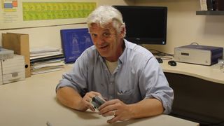 Robert Murray-Smith showing off the paper battery he's just made.