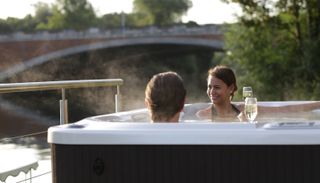 Two people in a hot tub by a river