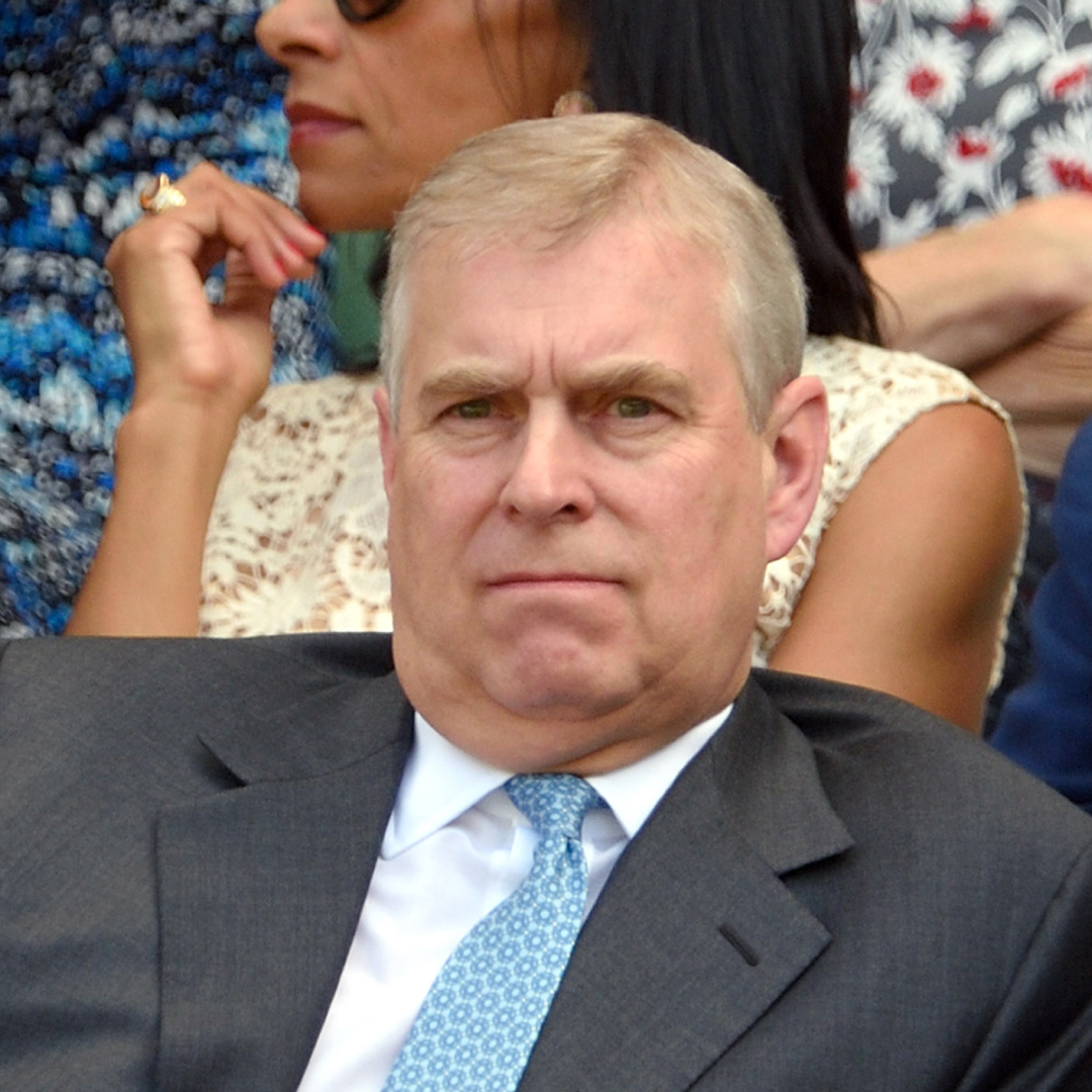 Andrew Mountbatten-Windsor wearing a gray suit and blue tie at Wimbledon