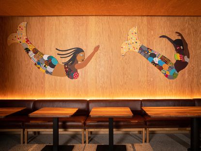 Artwork Black mermaids by Derrick Adams on wooden wall at Hav & Mar restaurant in New York