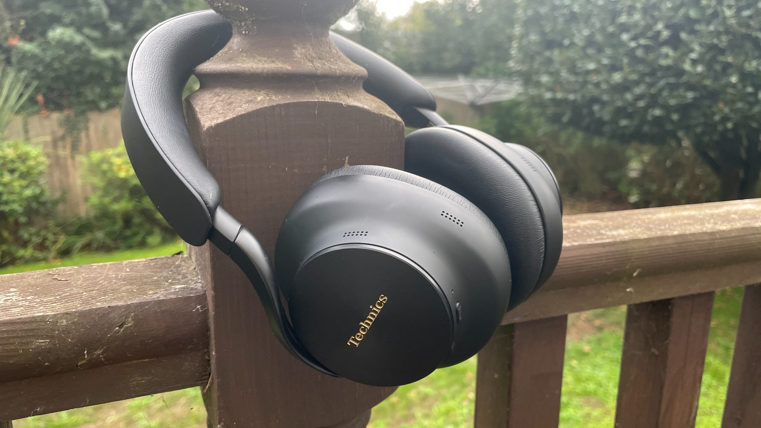 Technics EAH-A1000 headphones in black, in a garden