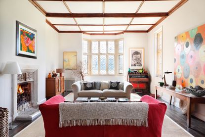 living_room_with_bay_window_beams_fireplace_art