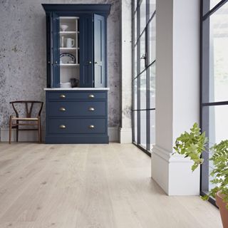 room with wooden floor and textured wall and blue cabinet and chair