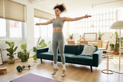 Woman doing a star jump during an at-home workout