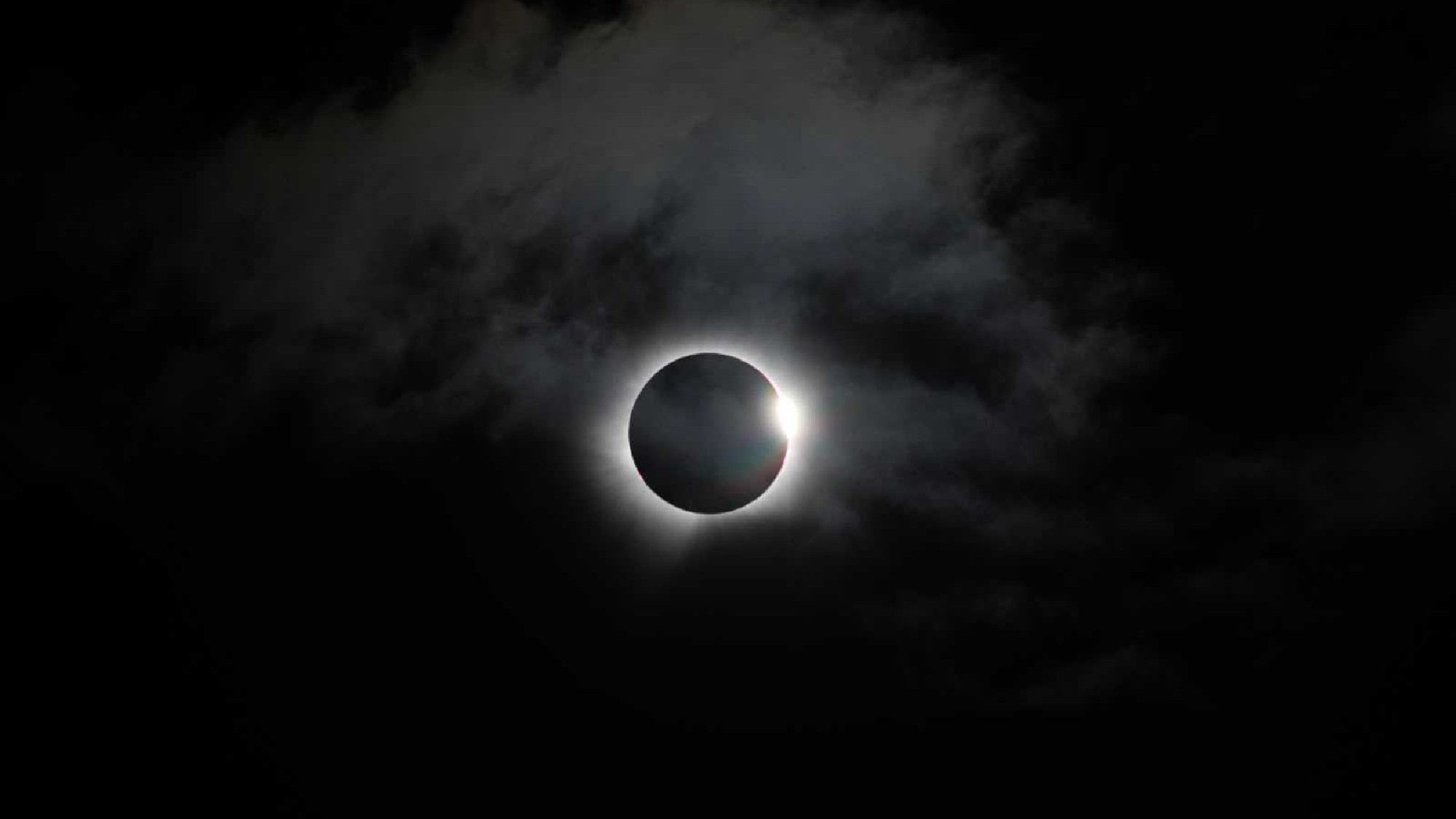 a thin white line of wispy light on a black background
