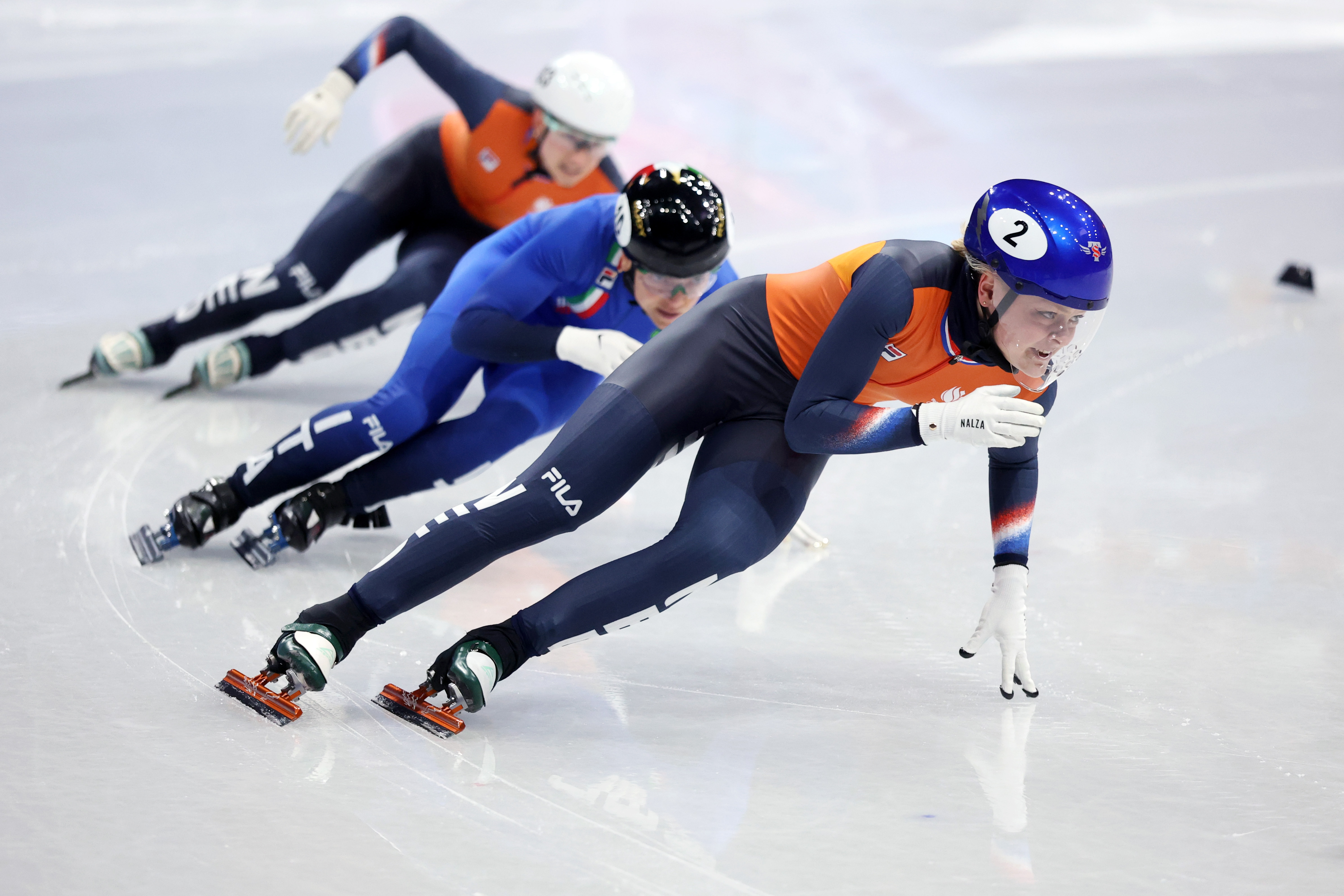 Three athletes competing in short track speed skating