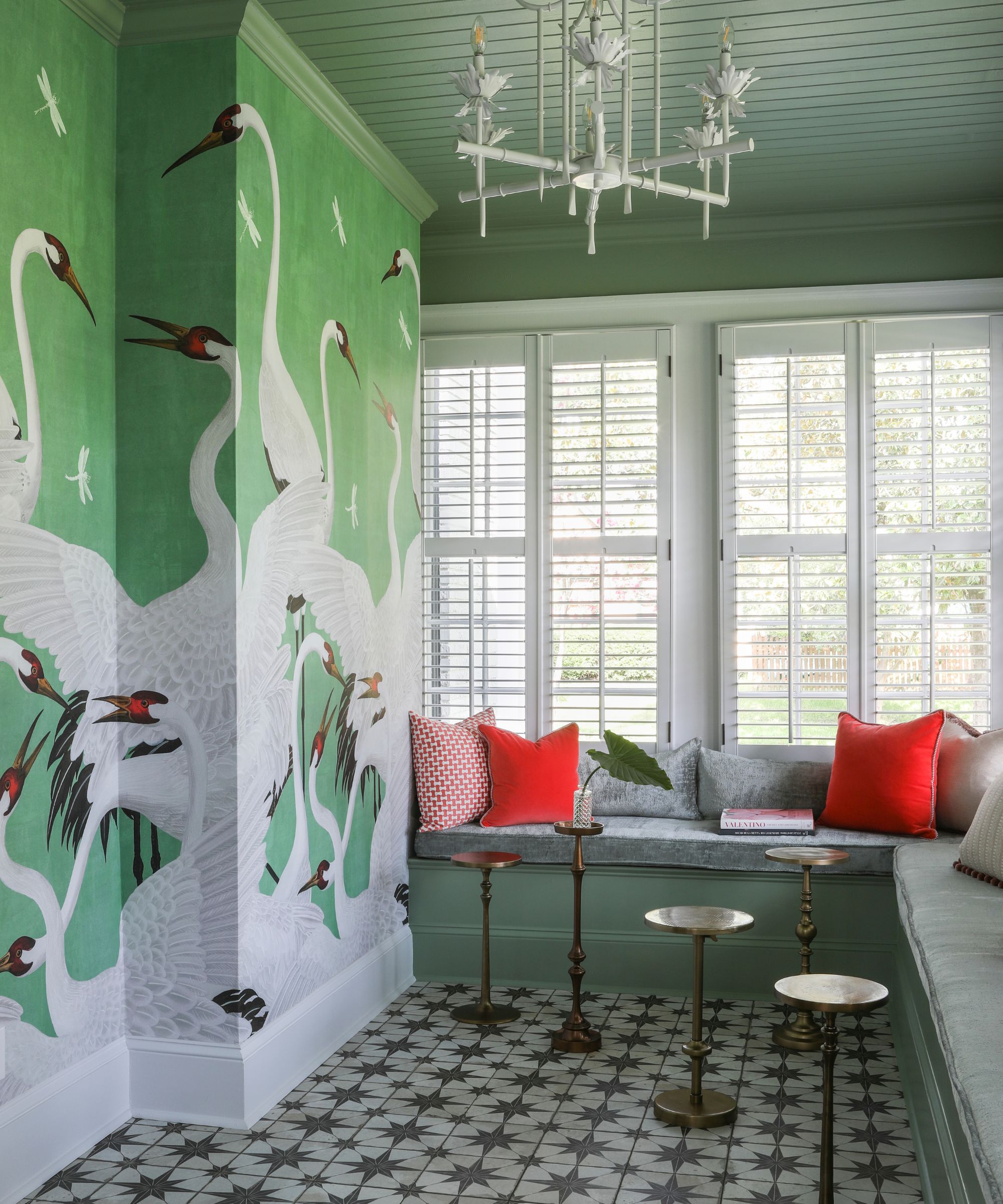 dining nook with pistachio green wall mural with swans, sage green ceiling and upholstered corner seating bench in front of windows