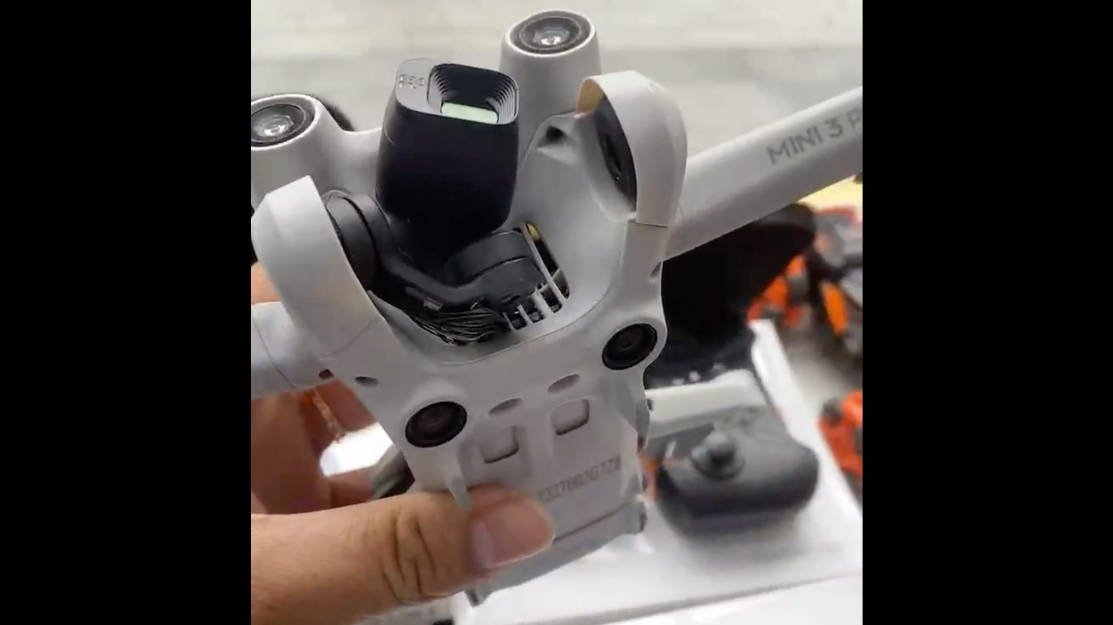A hand holding a prototype of the DJI Mini 3 Pro