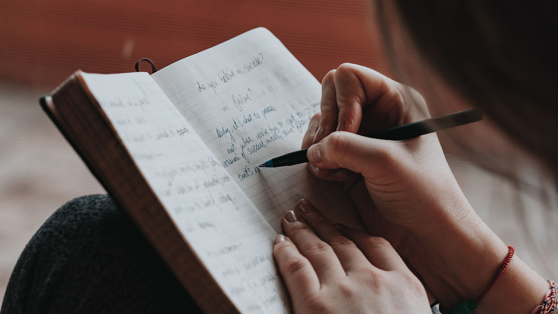 Frau schreibt in ein Notizbuch