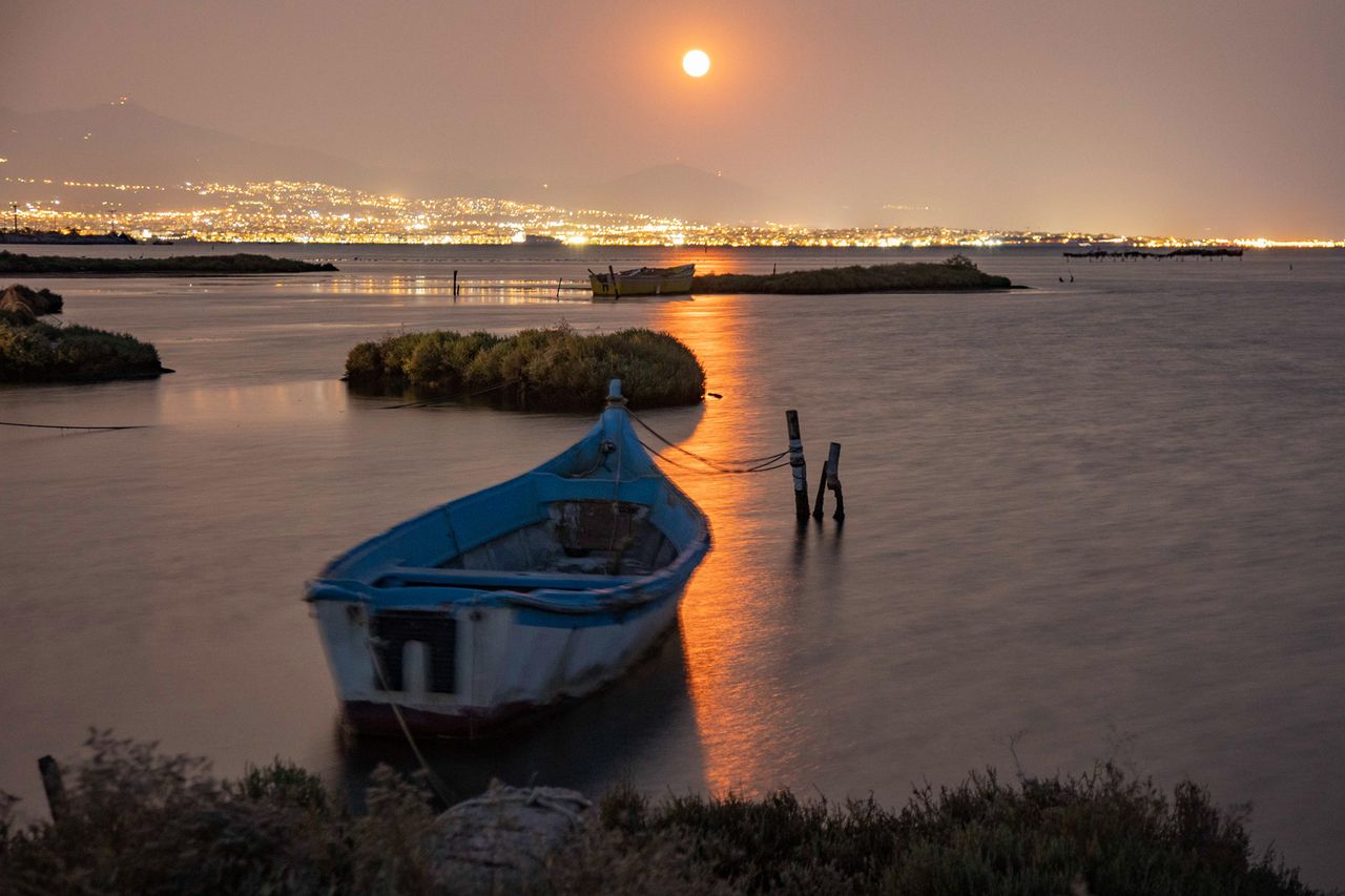 The August Sturgeon full moon rises behind the Hortiatis mountain and Thessaloniki city in Greece, on Aug. 22, 2021.