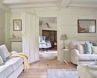 sitting room and adjoining hall space in an old cottage decorated with a neutral scheme