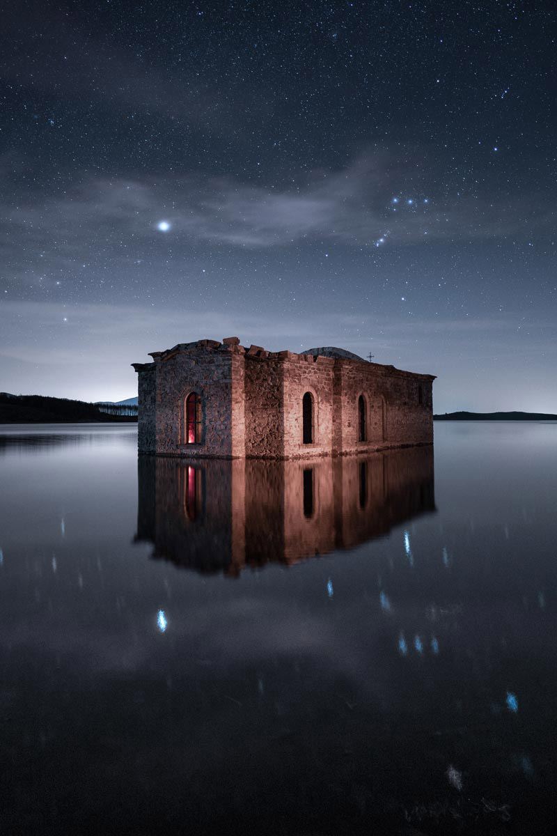 A submerged church partially underwater at night