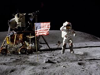 John Young, astronaut and Navy veteran, salutes the U.S. flag at the Descartes landing site during the first Apollo 16 extravehicular activity (EVA-1). Young, commander of the Apollo 16 lunar landing mission, jumps up from the lunar surface as astronaut and Air Force veteran, Charles M. Duke Jr., lunar module pilot, took this picture.